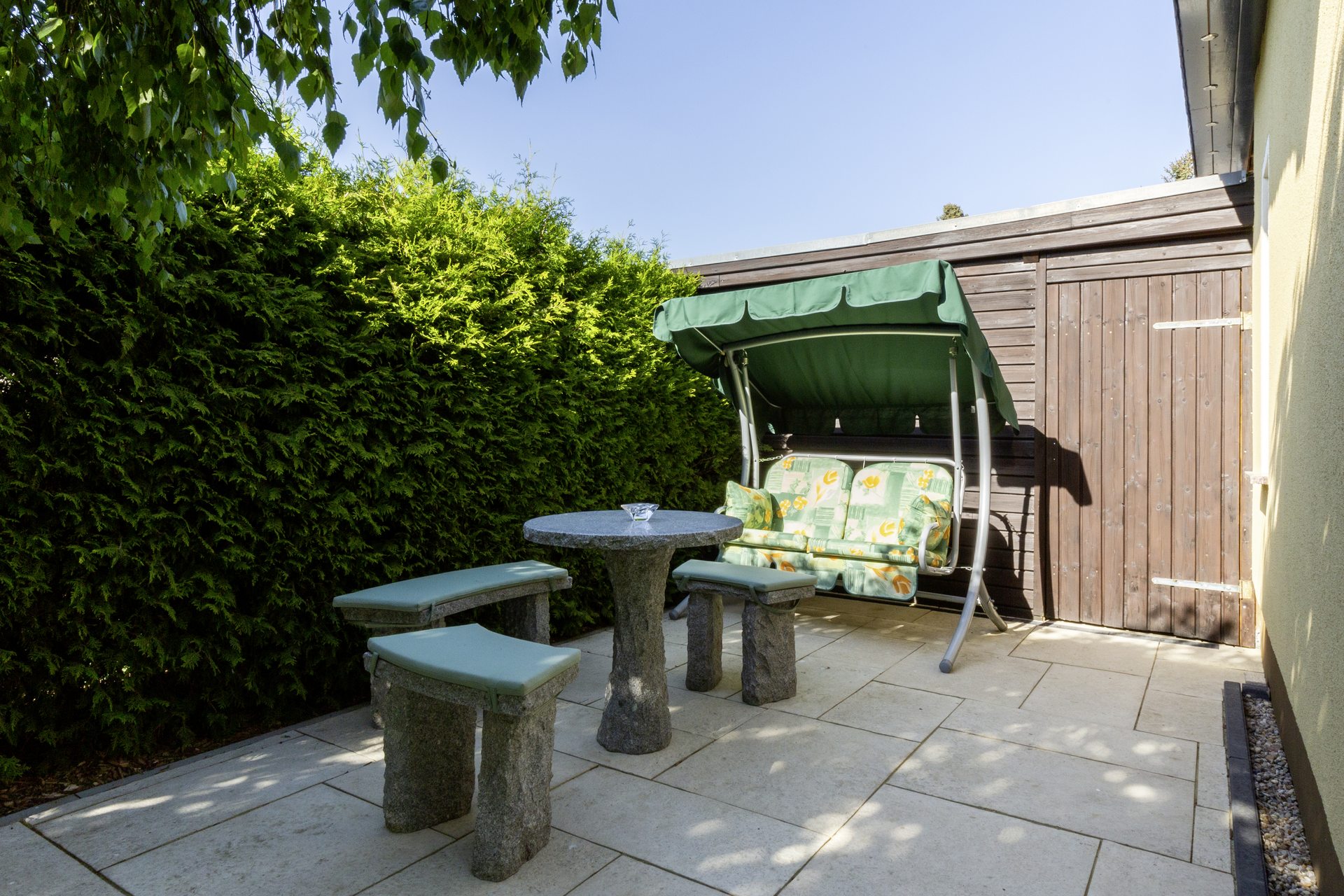 Sitzgruppe mit Hollywoodschaukel im Garten